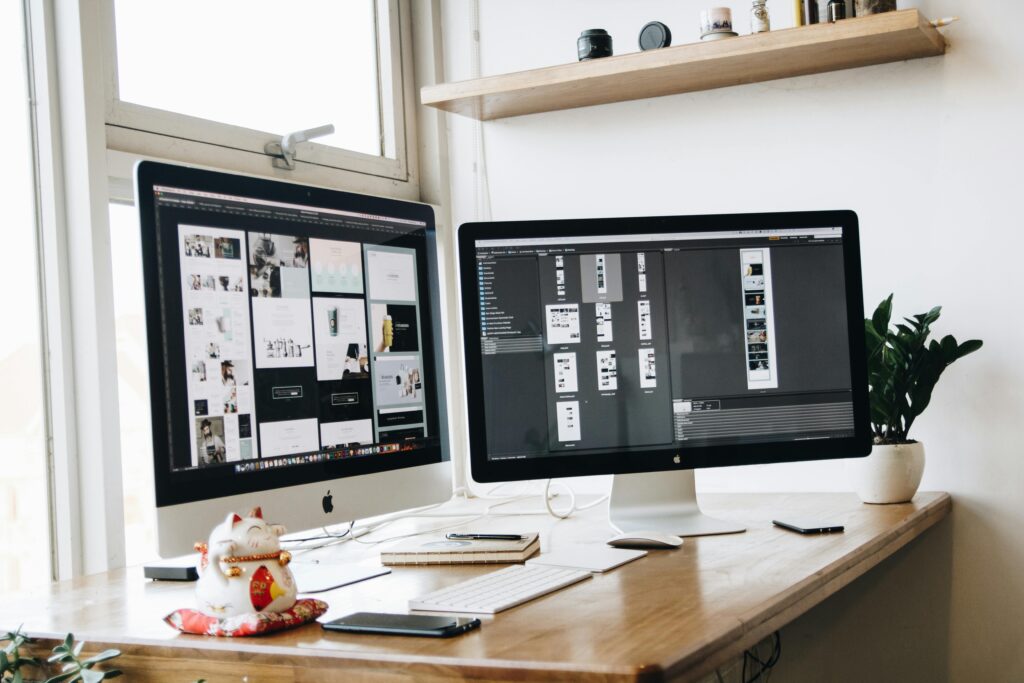 A clean, organized workspace featuring dual monitors, ideal for productivity and creative work.